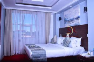- une chambre avec un grand lit et une fenêtre dans l'établissement Selella Resort, à Kisumu