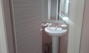 a bathroom with a white sink and a mirror at albergo Elena 3 SELF CHECK-IN in Parma