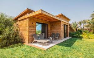 uma pequena cabana de madeira com cadeiras e uma mesa num quintal em Iberostar Mehari Djerba em Taguermess