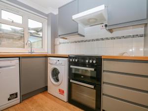 a kitchen with a stove and a dishwasher at 12 Parkers Hill in Thame