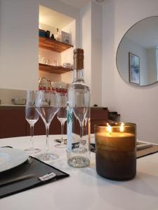 a table with wine glasses and a bottle and a candle at Le Plongeoir, intra-muros in Saint Malo