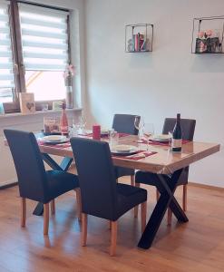 a dining room table with chairs and wine glasses at Ferienwohnung Odenwaldblick in Momlingen