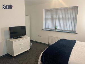 a bedroom with a bed and a tv on a dresser at Kunda House Seymour Oldbury in Oldbury