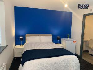 a bedroom with a blue wall and a bed at Kunda House Seymour Oldbury in Oldbury