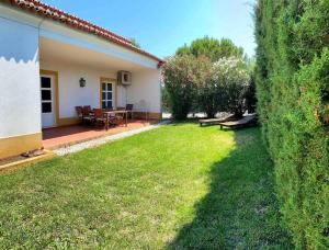 a yard with a house and a table and chairs at Casa das Clarinhas in Monforte