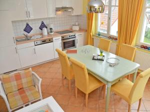 a kitchen with a table and chairs in a kitchen at "Villa Laetitia" - WG 15 - zentral, strandnah, 2 Balkone in Binz