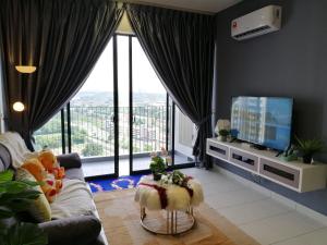 ein Wohnzimmer mit einem Sofa und einem TV in der Unterkunft Astetica Residences @ Seri Kembangan in Seri Kembangan