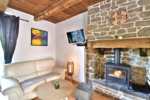 sala de estar con sofá y chimenea de piedra en Gites Mont Saint Michel "AUCOEURDELABAIE", en Sains