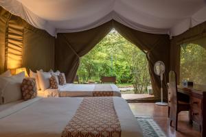 a bedroom with two beds in a tent at PrideInn Mara Camp & Cottages in Talek