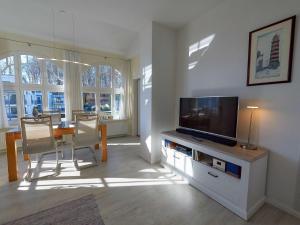 a living room with a television and a table and chairs at Villa Li - Fewo 06 "Sonneninsel" in Ostseebad Sellin