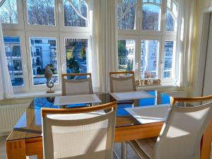 a dining room with a table and chairs and windows at Villa Li - Fewo 06 "Sonneninsel" in Ostseebad Sellin