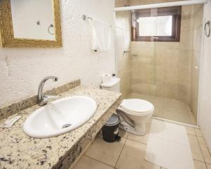 La salle de bains est pourvue d'un lavabo, de toilettes et d'une douche. dans l'établissement Pousada do Mica, à Praia do Rosa