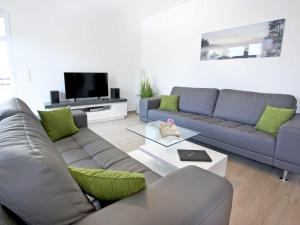 een woonkamer met een bank en een tv bij Villa Louisa - Wohnung 51 in Ostseebad Sellin
