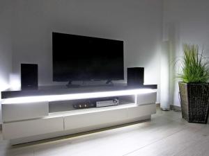 a entertainment center with a tv on a wall at Villa Louisa - Wohnung 51 in Ostseebad Sellin