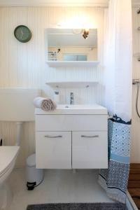 a white bathroom with a sink and a toilet at 84, gelegen in het rustige & bosrijke Oisterwijk! Met privétuin in Oisterwijk