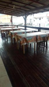 una fila de mesas sentadas en la parte superior de un suelo de madera en Pousada Rota do Parque, en Penha