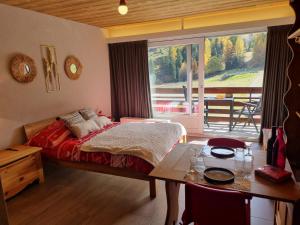 una camera con letto, tavolo e finestra di Magnifique studio rénové au coeur des 4 Vallées a Nendaz