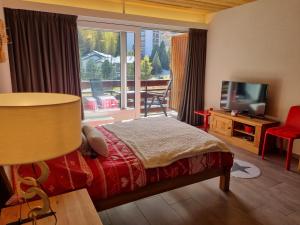 a bedroom with a bed and a large window at Magnifique studio rénové au coeur des 4 Vallées in Nendaz