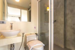 a bathroom with a toilet and a sink and a shower at Montree Phuket Hotel, SHA Extra Plus in Phuket Town