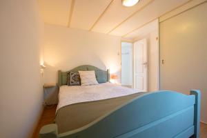 a bedroom with a bed with a blue headboard at 84, gelegen in het rustige & bosrijke Oisterwijk! Met privétuin in Oisterwijk