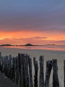 a group of wooden posts on the beach at sunset at Maison Saint-Coulomb in Saint-Coulomb