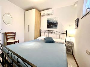 a bedroom with a bed and a chair at VILLA BLUE PANORAMIC PORTOVENERE in Portovenere