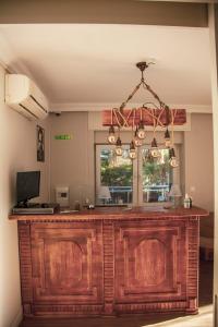 a kitchen with a large wooden bar with a chandelier at Aden Boutique Otel in Çeşme