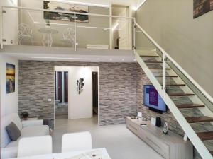 a living room with a staircase and a brick wall at Daydreamer House in Catania