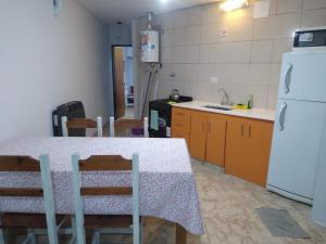 une cuisine avec une table avec des chaises et un réfrigérateur dans l'établissement Patagonia Beach Las Grutas!, à Las Grutas