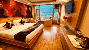 ein Hotelzimmer mit einem Bett und einem großen Fenster in der Unterkunft Hotel Old Smugglers with Balcony mountain view(A/C hot and Cold) in Manali