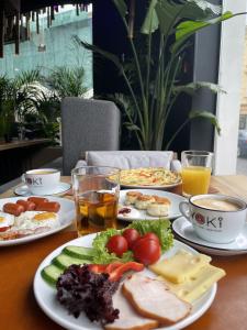 - une table avec des assiettes de nourriture et de boissons dans l'établissement Rius Hotel Lviv, à Lviv