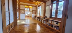 a library with bookshelves and windows in a building at Chaehyodang Hanok Stay in Seoul