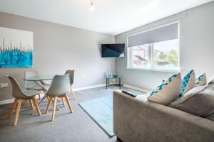 uma sala de estar com um sofá e uma mesa em Monicas Apartment Lovely ground floor 2 bedroom serviced apartment em Coatbridge