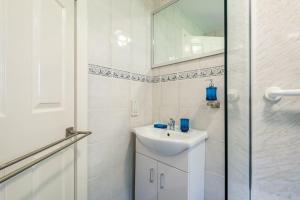 a white bathroom with a sink and a shower at Monicas Apartment Lovely ground floor 2 bedroom serviced apartment in Coatbridge +46 photos