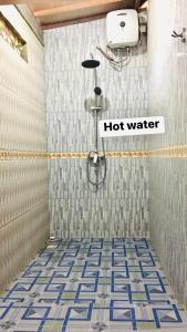 a shower stall with a hot water sign in a bathroom at Wahyu Homestay 1 in Nusa Lembongan
