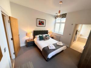 a bedroom with a bed with two pillows on it at Urban Living's - Windsor Castle Luxury Apartments in Windsor