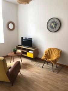 sala de estar con silla y TV en Appartement en duplex à Auxonne, en Auxonne