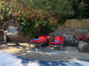 ケープタウンにあるHome Suite Hout Bayの庭に赤い椅子2脚とテーブル1台