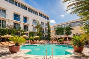una piscina frente a un edificio en The Plymouth South Beach, en Miami Beach