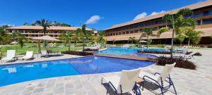 プライア・ドス・カルネイロスにあるEco Resort - Pé na areia da Praia dos Carneirosのプールと椅子のあるホテル