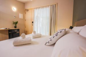 1 dormitorio con 1 cama blanca grande y toallas. en Mythic Valencia, en Valencia