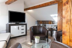 sala de estar con TV, mesa y sillas en Beachfront apartments Calm Sea, en Preko