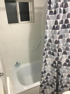 a bathroom with a bath tub and a shower curtain at Departamento en Pelluco, Puerto Montt in Puerto Montt +5 photos