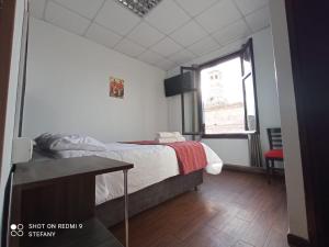 1 dormitorio con cama, ventana y mesa en Catedral, en Arequipa