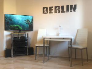 a room with a table and two chairs and a television at "IDEAL" - für Zwei in Berlin