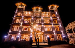 un edificio alto con luces encendidas por la noche en Hotel Old Smugglers with Balcony mountain view(A/C hot and Cold), en Manali