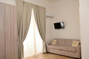 sala de estar con sofá y ventana en Olimpia Residence, en Caserta