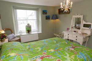 a bedroom with a bed and a dresser and a mirror at SEED Hub in Wincanton