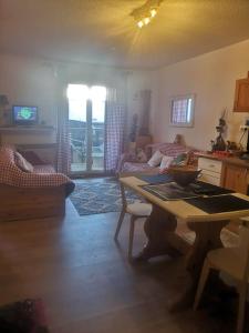 sala de estar con mesa y sofá en Auron, 2 pièces meublé, coin montagne,6 couchages, en Auron
