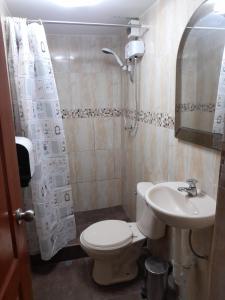 ein Badezimmer mit einem WC, einem Waschbecken und einem Spiegel in der Unterkunft Casa Navarra in Lima